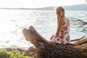 Woman on rock sitting by the ocean