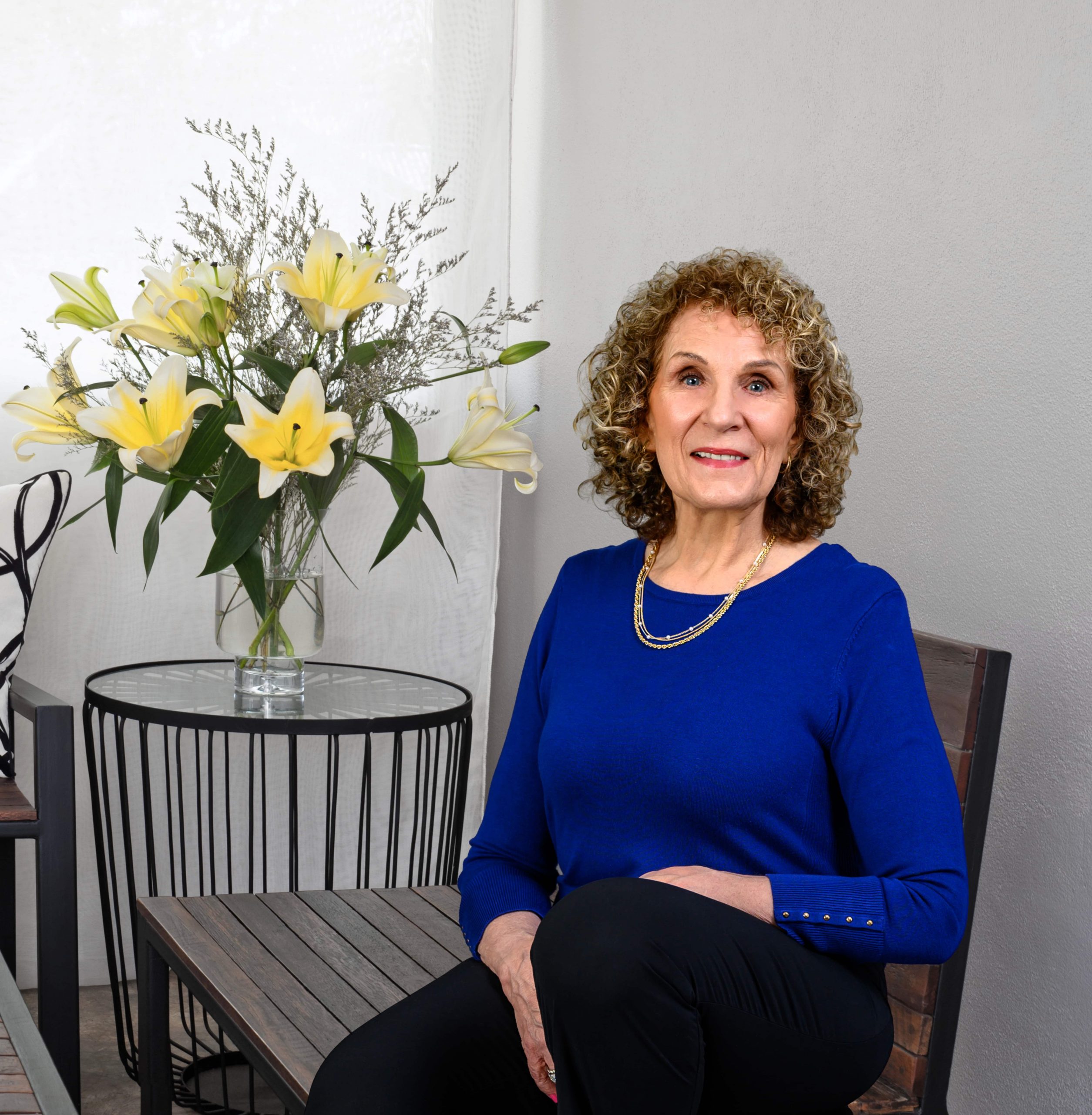 Coach Linda Trignano sitting on bench beside flowers