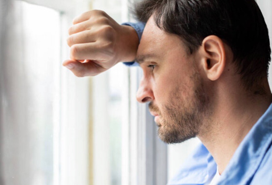 Sad grieving man at window
