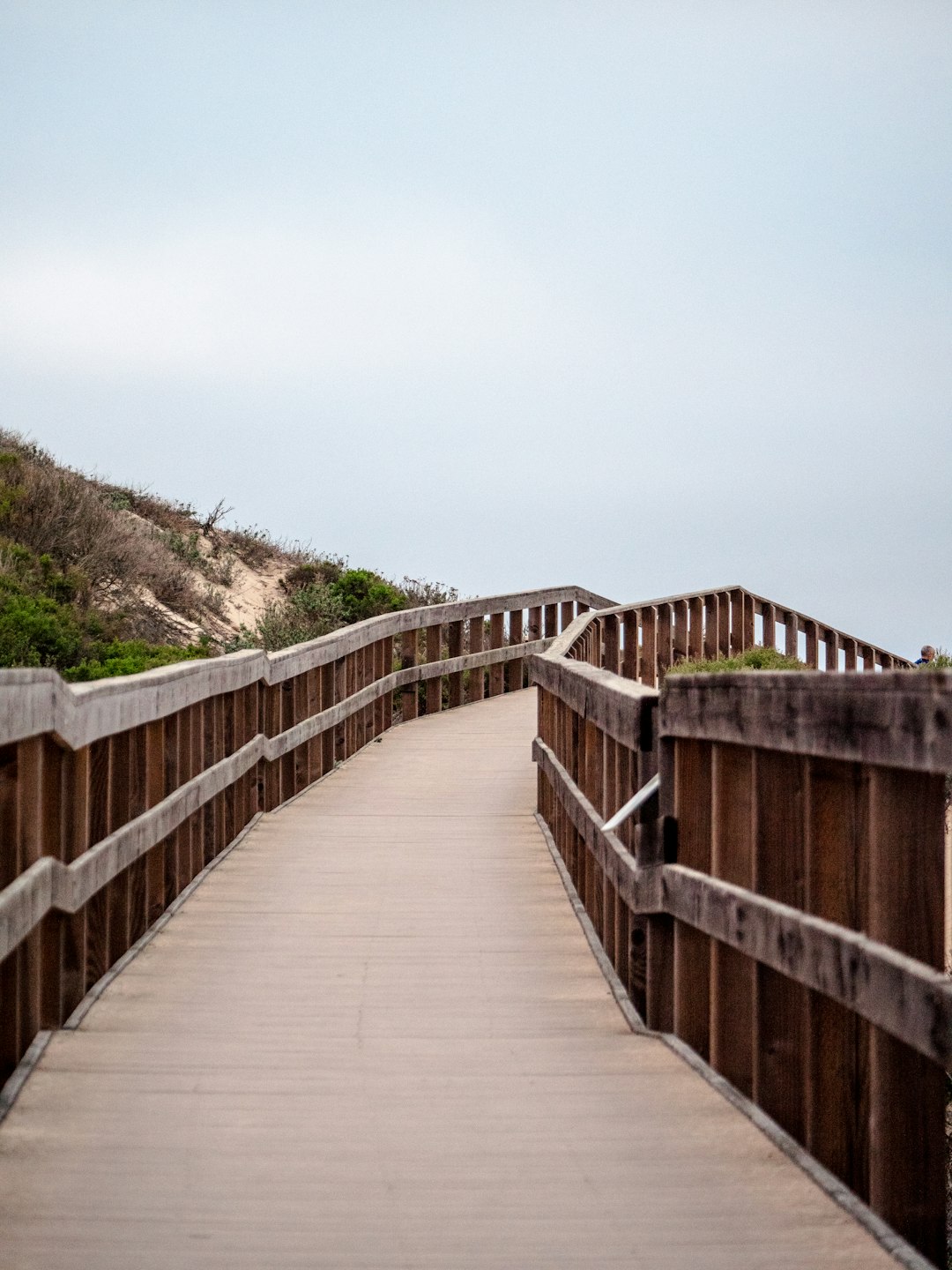 brown wooden bridge over green grass field during daytime brown wooden bridge over green grass field during daytime